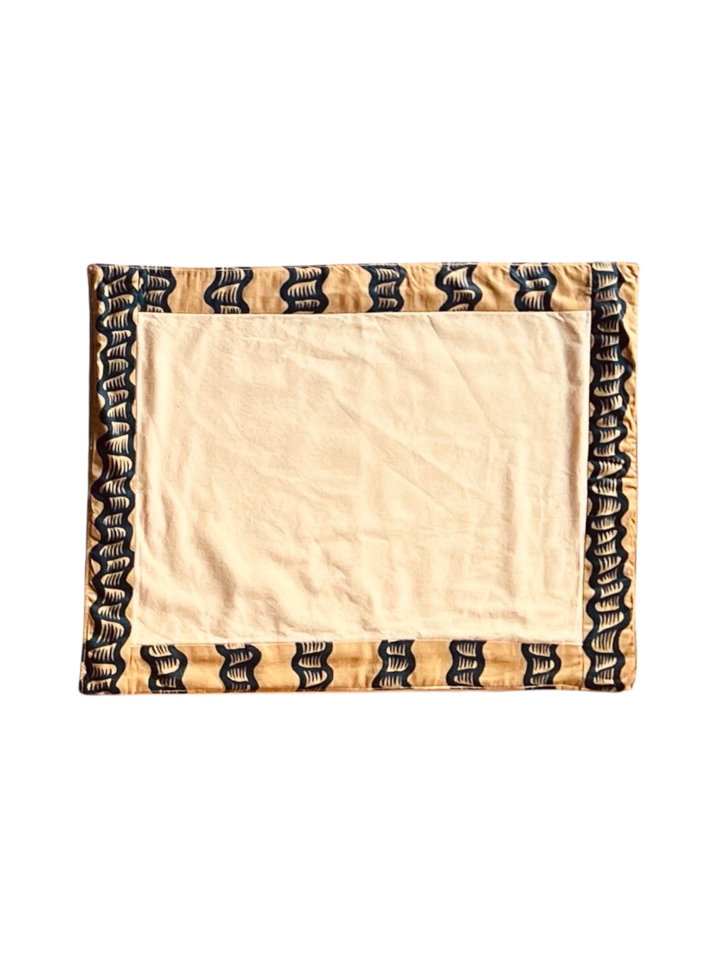 A rectangular placemat with a beige center and black and blue patterned borders.