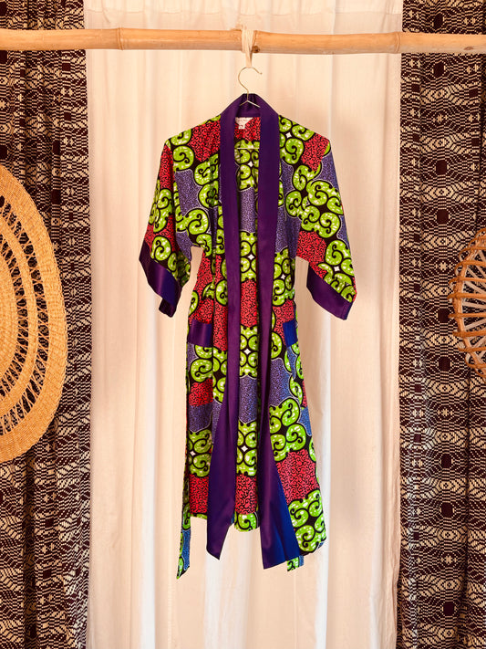 Colorful patterned robe hanging on a rack with decorative elements in the background