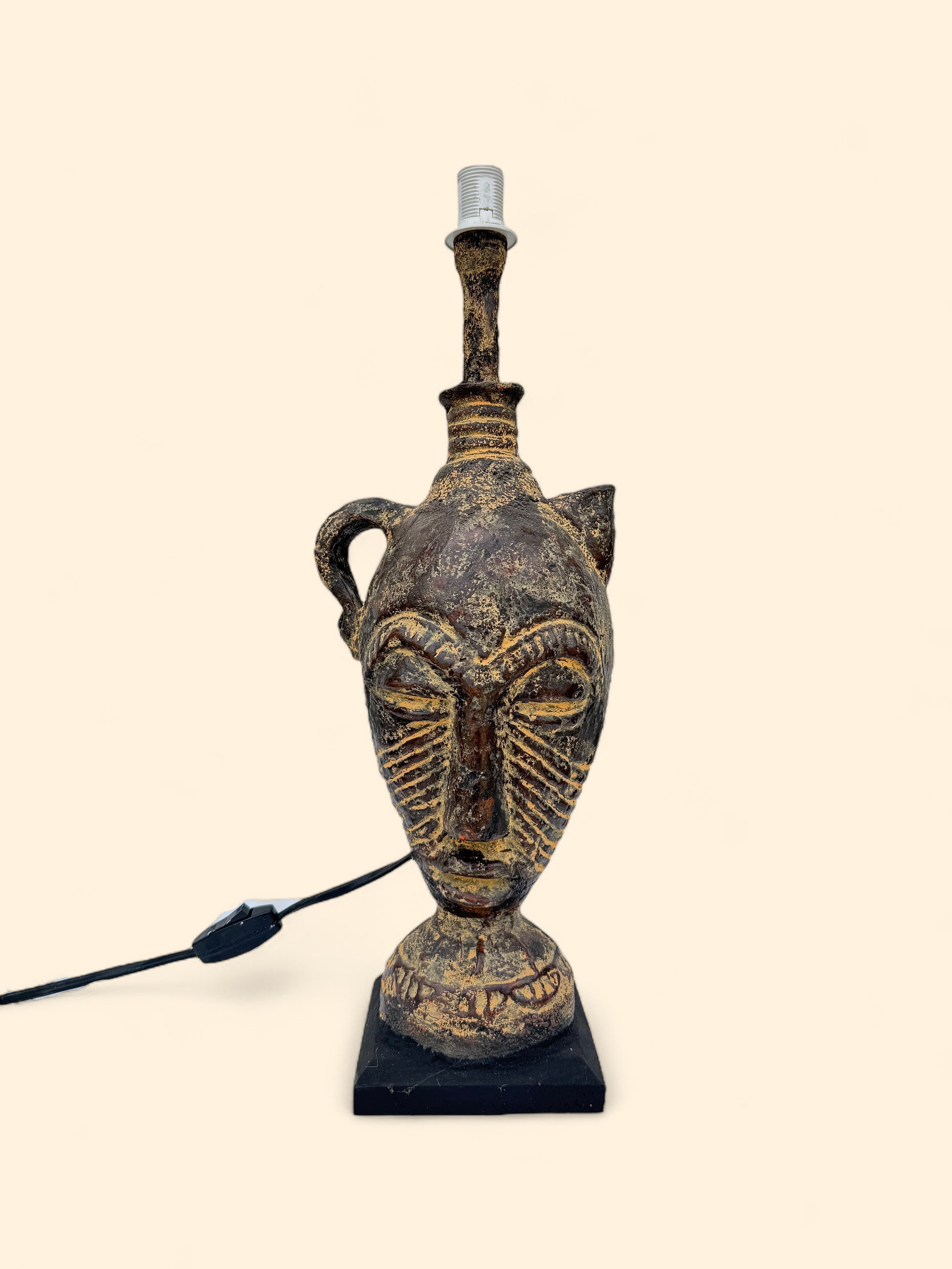 Decorative lamp with face design on a beige background