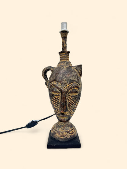 Decorative lamp with face design on a beige background