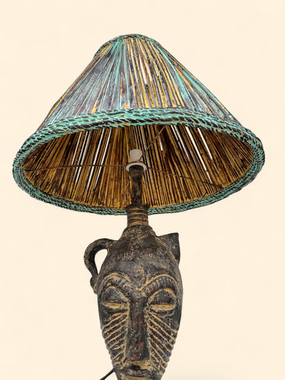 Decorative lamp with a face design and a wicker shade on a beige background