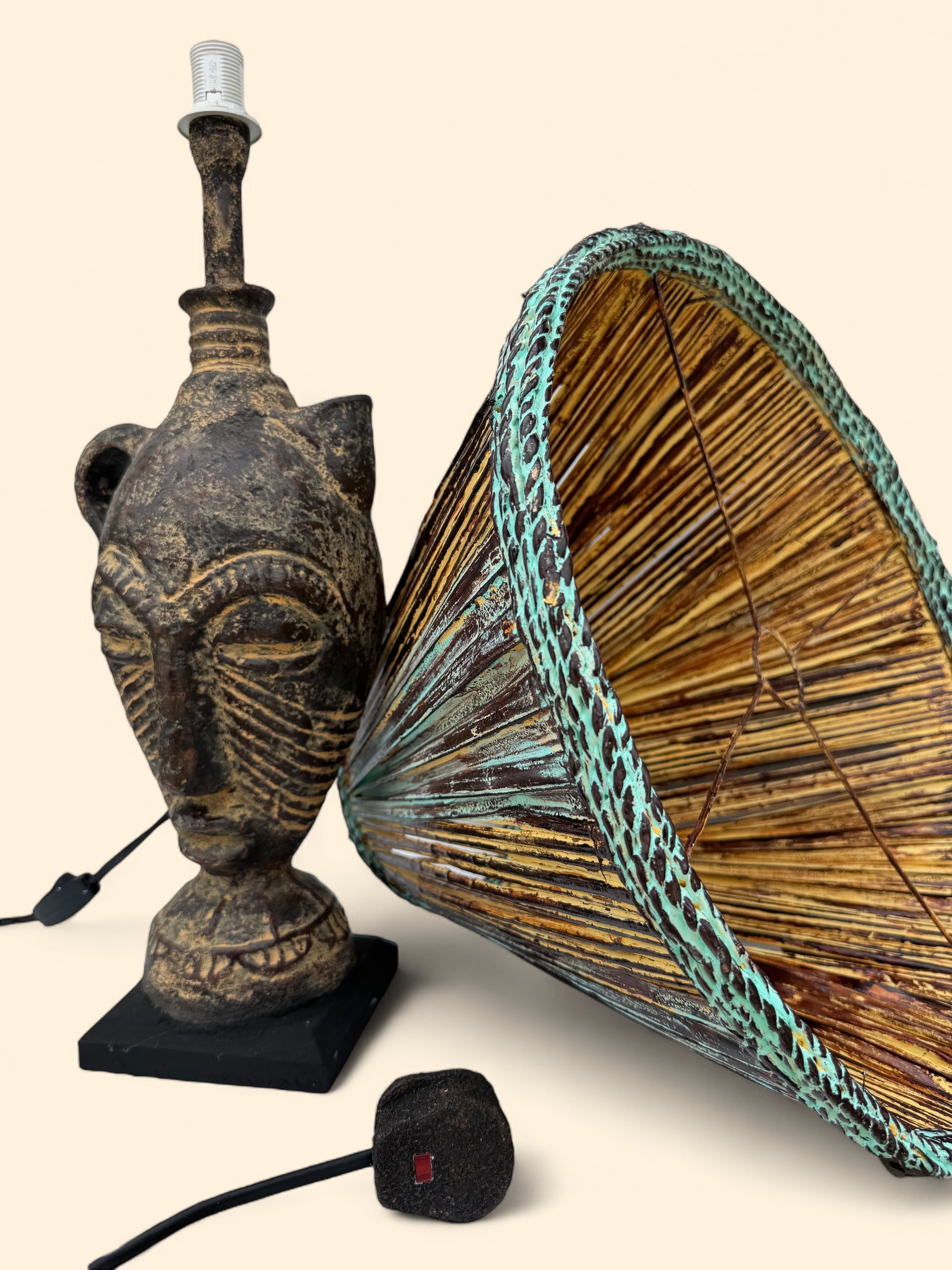 Decorative lamp with African mask design and woven shade on a beige background